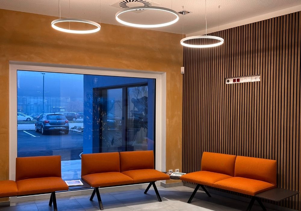 Moderner Wartebereich mit farbenfroher Wandgestaltung, Sitzmöbeln und Wandzitat – Wohnatelier im Schlossquartier in Eisenstadt